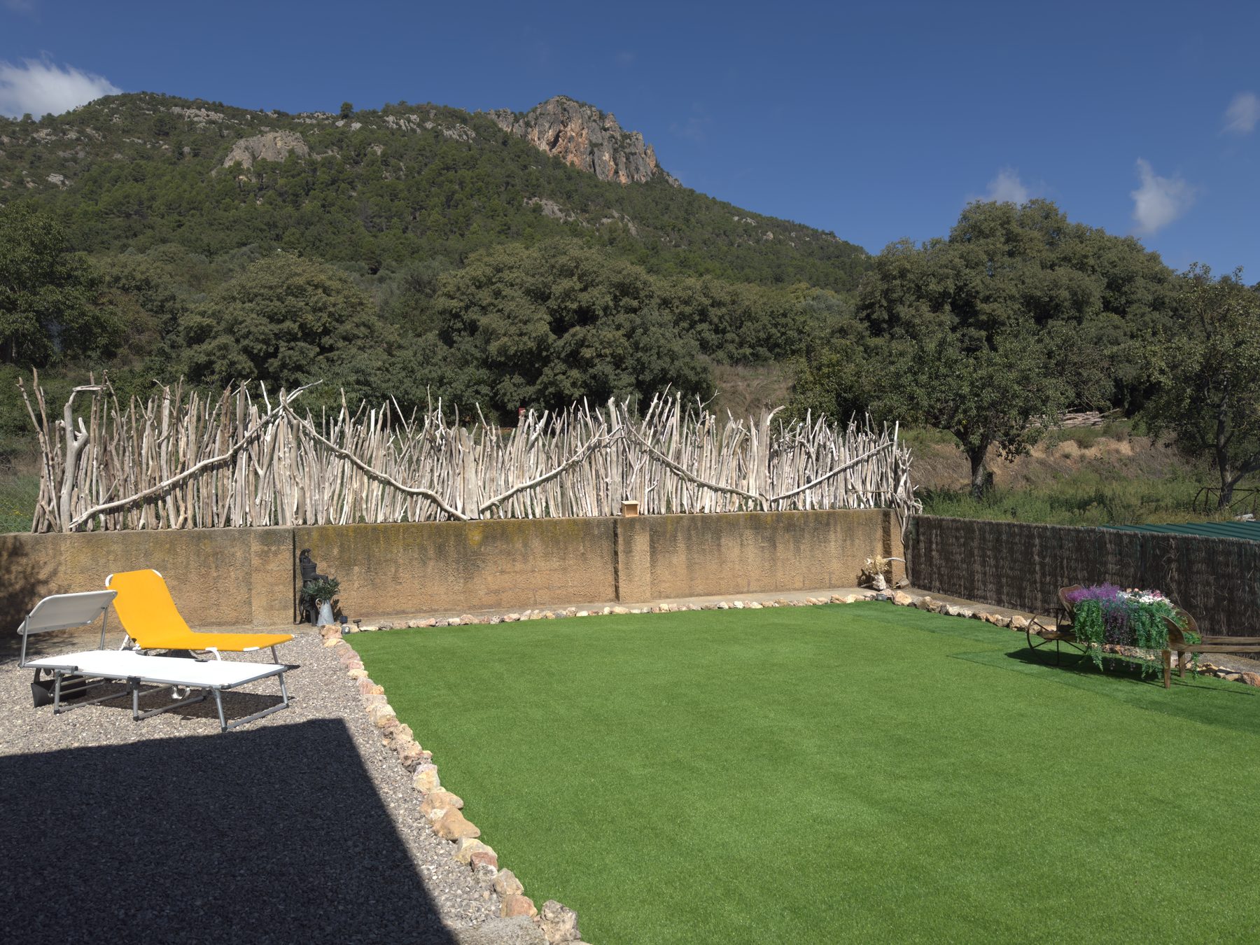 Jardí i pèrgola de Cal Quimet, amb el Roc de Rombau al fons